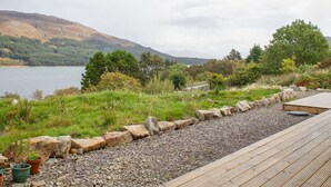 A wooden deck with a view of a lake and mountains. - Tigh Na Allt by Interhome (Mid Skye)