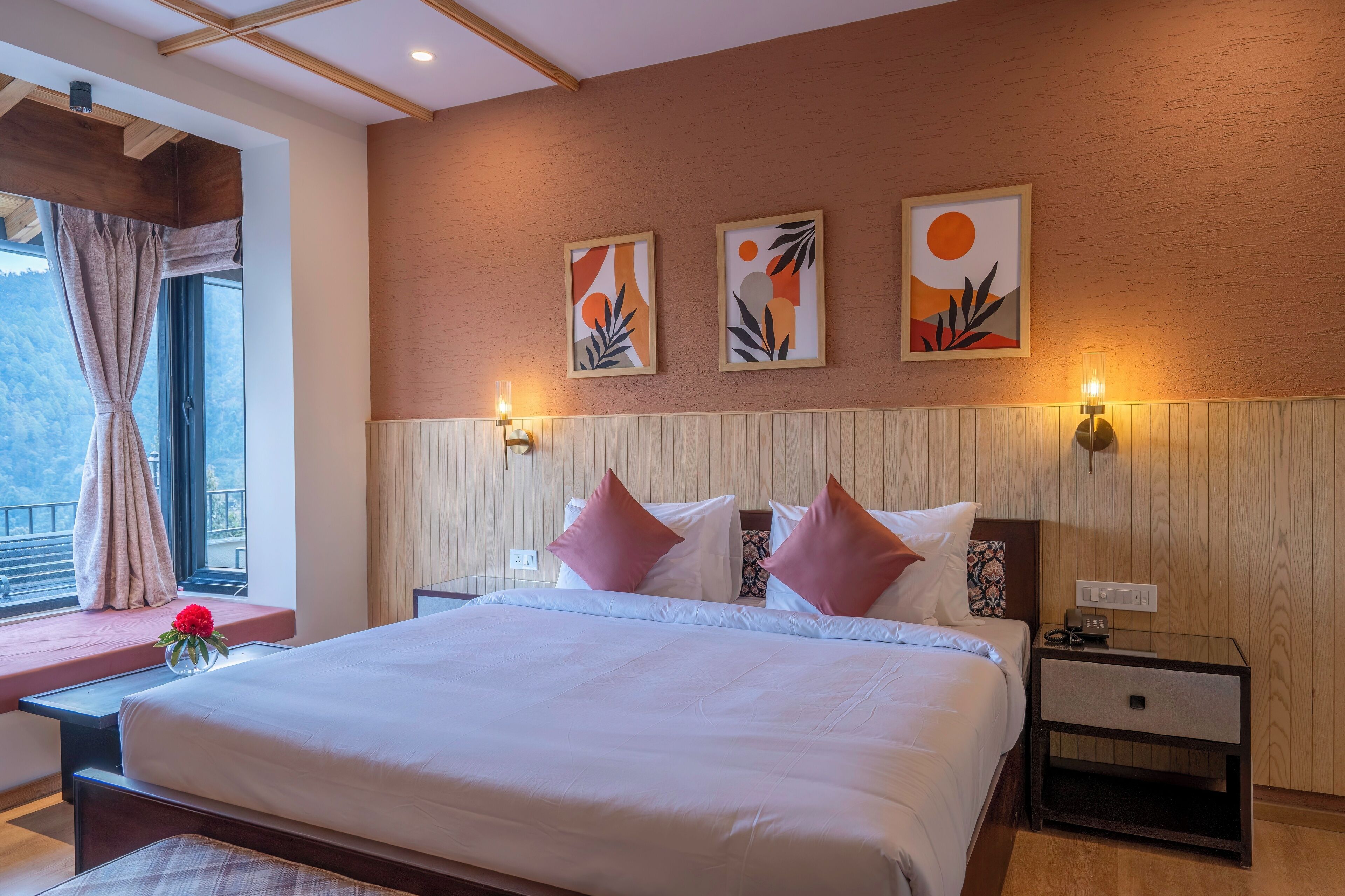 A bedroom with a large bed, wooden headboard, two bedside tables with lamps, and artwork on the wall.