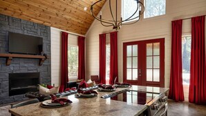 A modern kitchen with a large island, a built-in oven, and a stone fireplace. - Luxury Romantic Cabin - KingBed ~ Strip Lounge (Broken Bow)