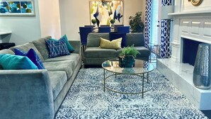 A living room with a grey sofa, a round coffee table, and a patterned rug. - Charming 3-bedroom ranch home, back deck, close to ATL, in peaceful Norcross (Norcross)