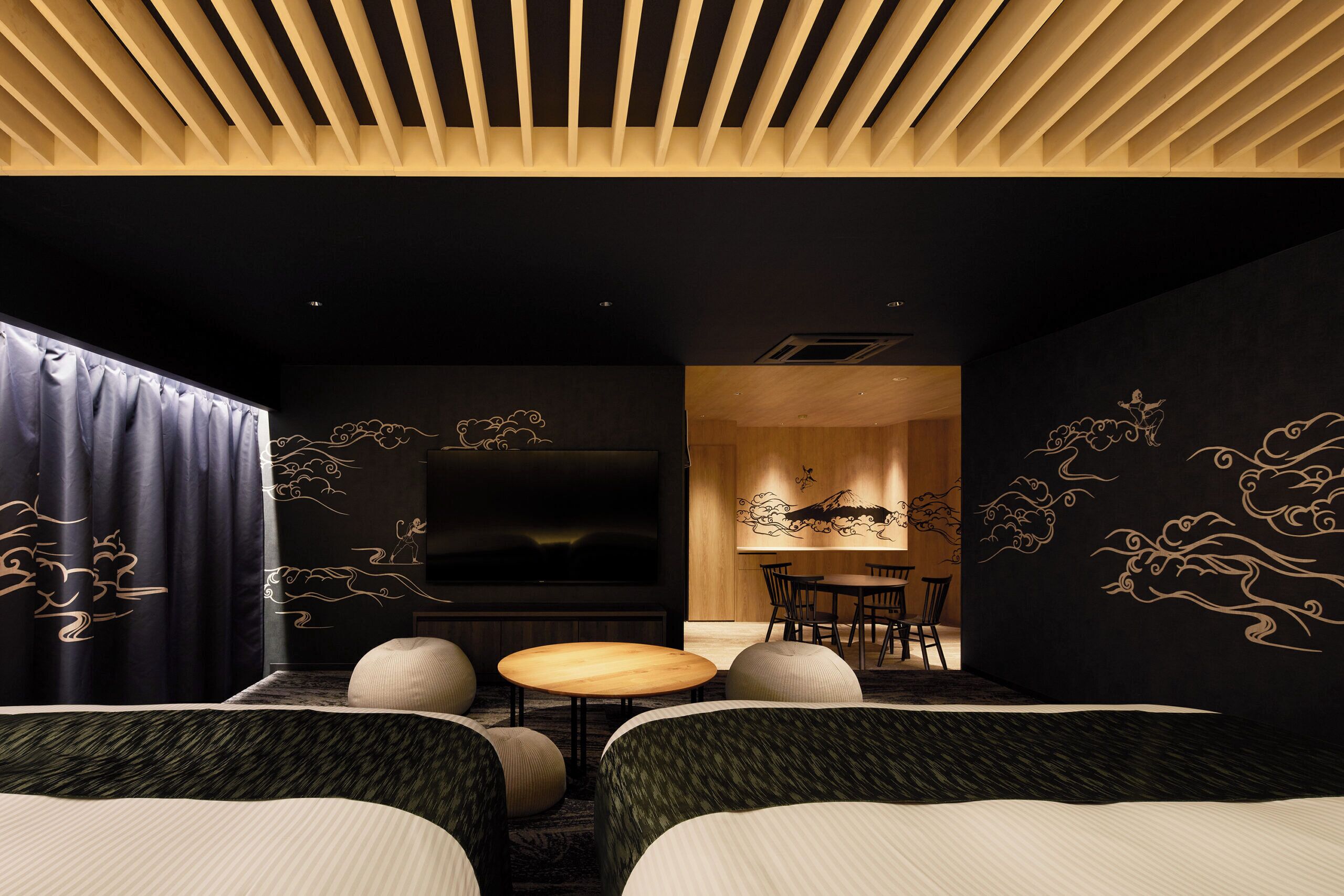 Habitación de hotel moderna con televisor, zona de estar y arte mural tradicional.