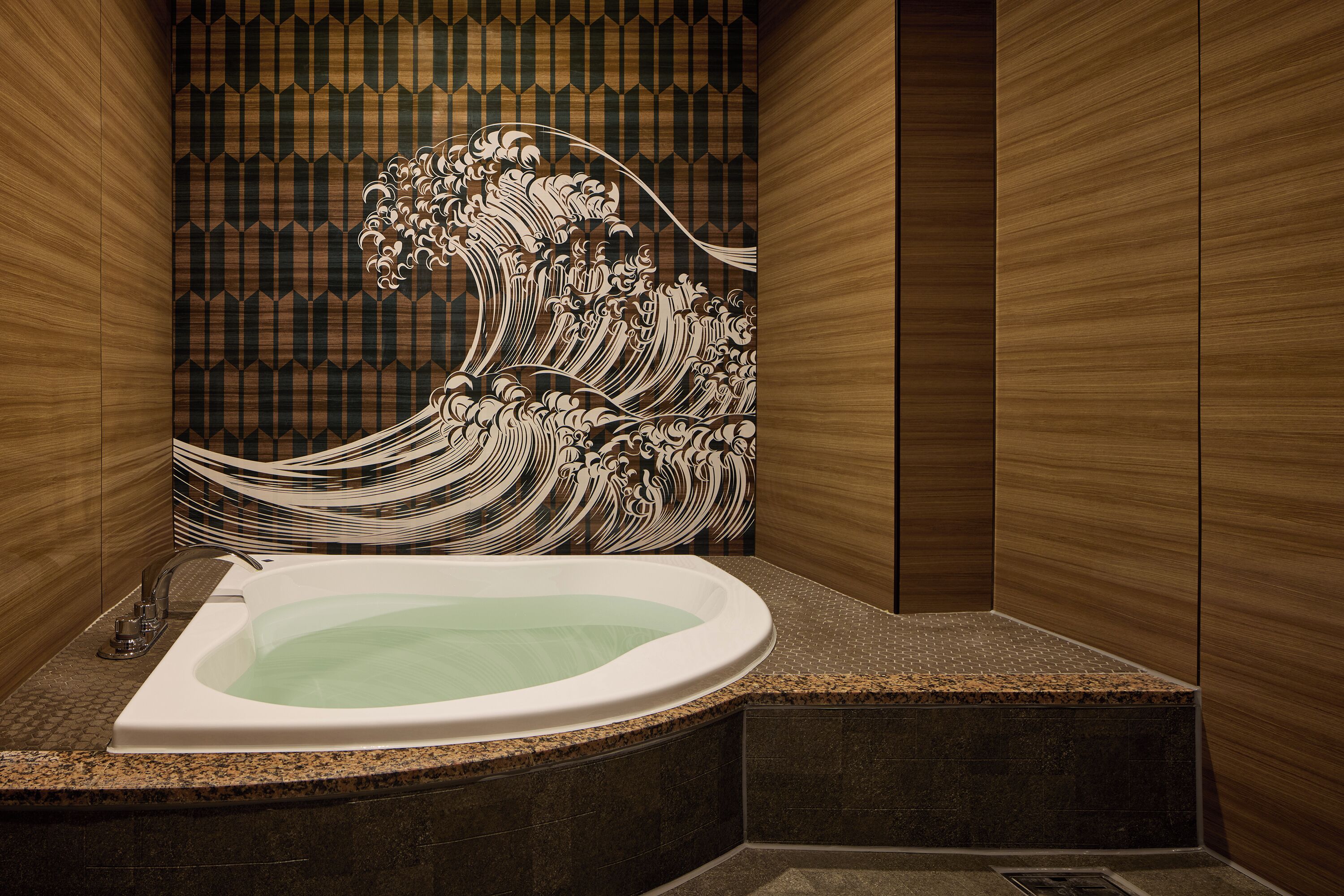 Un baño moderno con una bañera grande, un motivo decorativo de olas en la pared y un diseño de paneles de madera.