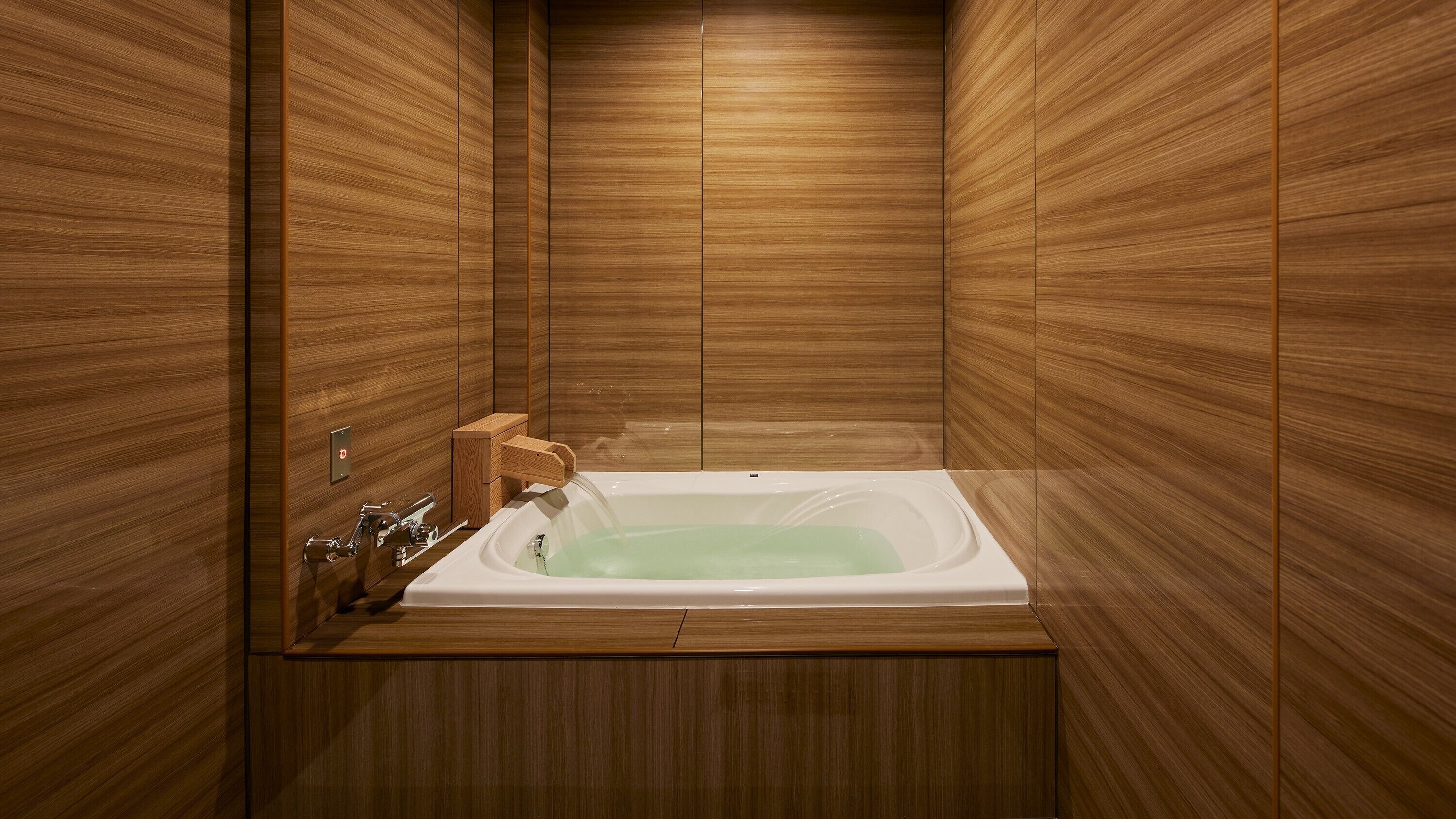 A modern bathroom with a wooden panel design, a freestanding bathtub, and a wooden vanity with a sink.
