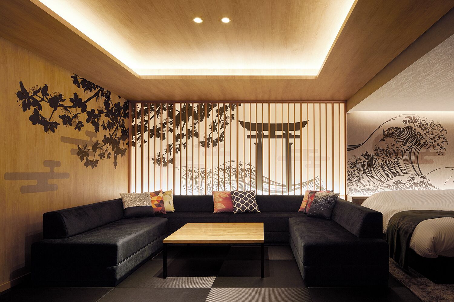 Una habitación moderna de estilo japonés con un conjunto de sofás, una mesa de centro de madera y una cama con diseño tradicional japonés.