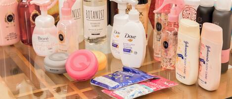 Variedad de productos de cuidado personal exhibidos sobre una mesa de vidrio.