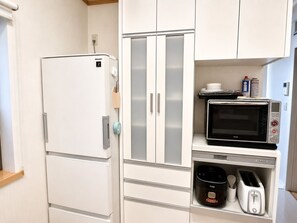 A compact kitchenette with a white refrigerator, a microwave, a toaster, and a coffee maker. - Yamanakako Resort House I (Yamanakako)