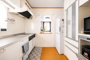 Eine kompakte Küche mit Herd, Backofen, Mikrowelle, Kühlschrank und einem Fenster mit Blick.