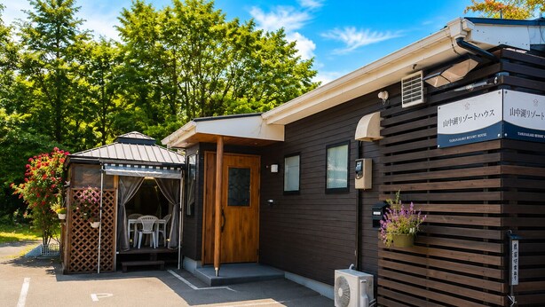 A small building with a wooden door and a sign that reads 'TAMAKAKO RESORT HOUSE.' - Yamanakako Resort House I (Yamanakako)