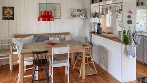 A cozy kitchen with a wooden dining table, bar stools, and a red pendant light. - Cozy home in Vejby with WiFi (Vejby)