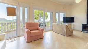 A spacious living room with a pink armchair, beige sofa, and a TV. - Awesome home in Orba with WiFi (Orba)