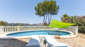 A swimming pool with a white balustrade, two lounge chairs, and a green shade sail. - Awesome home in Orba with WiFi (Orba)