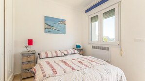 A bedroom with a bed, a nightstand, a lamp, a wall art of boats, a window, and a radiator. - Awesome home in Orba with WiFi (Orba)