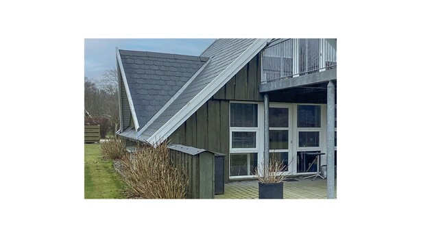 A building with a sloped roof, large windows, and a wooden exterior. - Awesome home in Samsø with WiFi (Samsø)