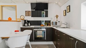 A modern kitchen with a white countertop, dark wooden cabinets, a built-in oven, a microwave, and a sink. - Stunning home in Vemb with WiFi (Vemb)