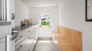 A narrow hallway with a wooden bench, a window with a view of greenery, and a white wall with a mirror. - Stunning home in Vemb with WiFi (Vemb)