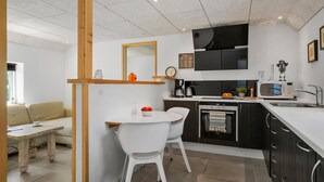 A compact kitchen with a dining area, a coffee machine, a microwave, and a small oven. - Stunning home in Vemb with WiFi (Vemb)