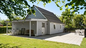 A single-story house with a covered patio area, a barbecue grill, and a small deck. - Stunning home in Vemb with WiFi (Vemb)
