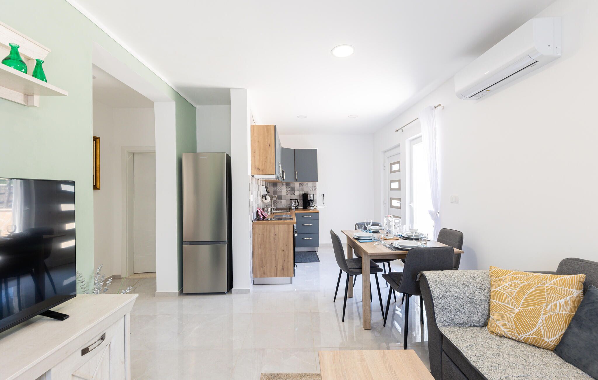 A modern apartment with a kitchen, dining area, and living room.