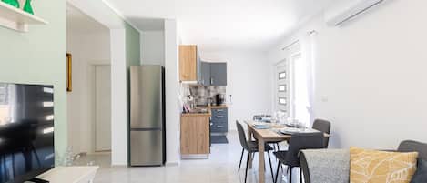 A modern apartment with a kitchen, dining area, and living room.