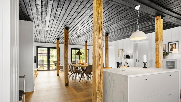 A modern kitchen with wooden beams, a marble island, and a dining area with natural light. - 4 bedroom beautiful home in Humble (Humble)