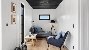 A cozy room with a wooden ceiling, a sofa, a chair, a small table, and a floor lamp. - 4 bedroom beautiful home in Humble (Humble)