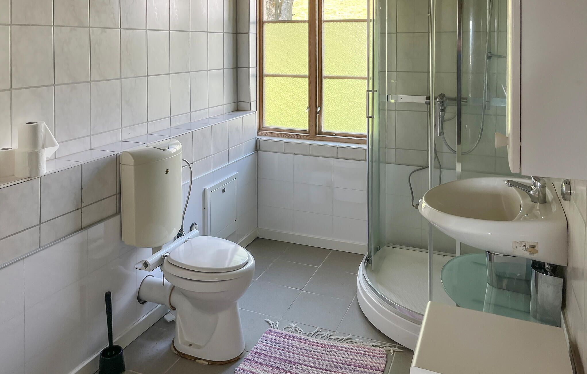 Une salle de bain avec des toilettes, une douche et un lavabo.