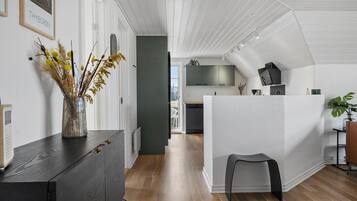 Une cuisine moderne avec un îlot central blanc, un plancher en bois et une vue sur la salle à manger.