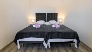 A double bed with a dark headboard, two bedside tables with lamps, and a wooden floor. - Lovely apartment in Ploce with WiFi (Ploce)