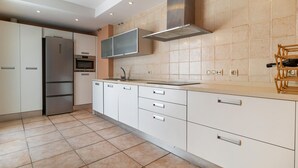 A modern kitchen with white cabinetry, a stainless steel range hood, and a tiled backsplash. - Awesome home in Tarifa with outdoor swimming pool (Tarifa)