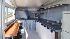 A compact kitchen with a built-in oven, a sink, and a fan.