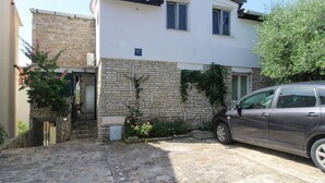 A two-story building with a stone facade and a car parked in the driveway. - Two bedroom amazing apartment in Milna (Milna)