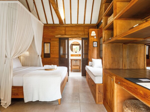 Una habitación tipo cabaña de madera con dos camas, un tocador y una pequeña zona de estar.