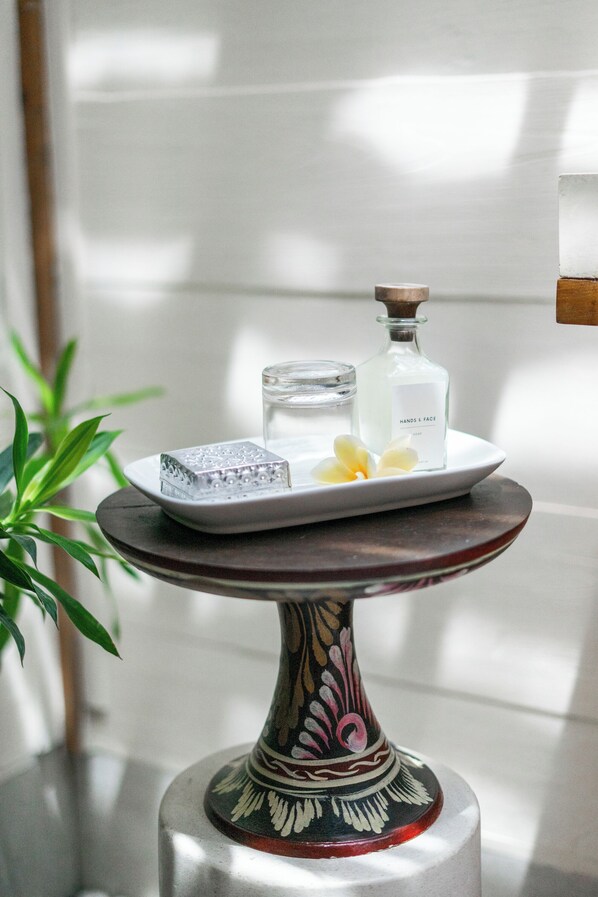Une table décorative avec un flacon en verre, un porte-savon et un verre d’eau.