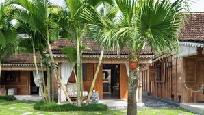 Eine Holzvilla mit Pool, umgeben von Palmen und einem gepflegten Rasen.