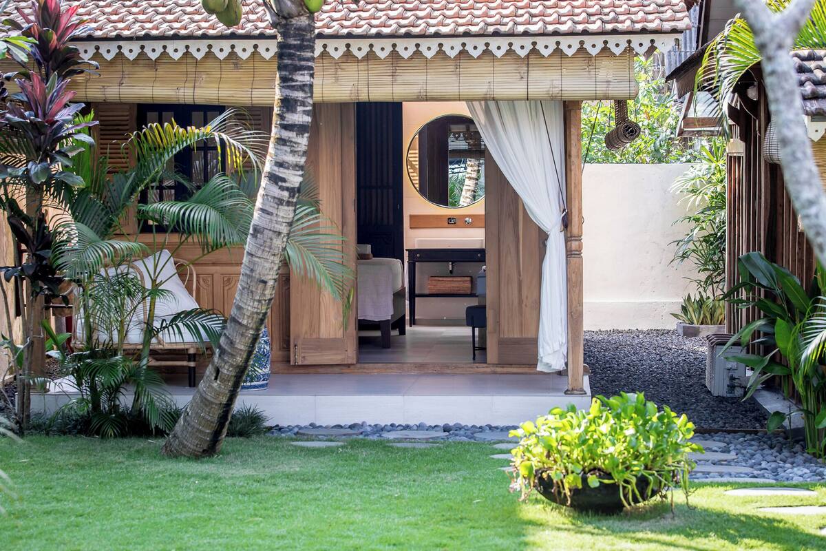 Een villa in tropische stijl met een eigen badkamer, een eetgedeelte en een weelderige tuin.