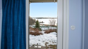 A view through a door with a wooden deck and snow-covered ground. - Amazing home in åkersberga with WiFi (Åkersberga)