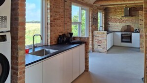 A modern kitchen with brick walls, a large window, and a built-in oven. - Nice home in Erslev with WiFi (Erslev)