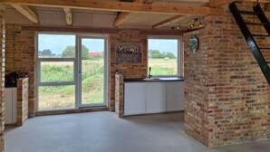 A kitchen with large windows, a brick wall, and a wooden ceiling. - Nice home in Erslev with WiFi (Erslev)