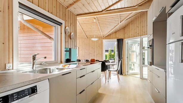A modern kitchen with wooden walls, a Bosch dishwasher, and a large window. - Pet-friendly home in Hejls with sauna (Hejls)