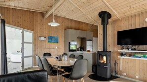 A modern kitchen with a central island, a built-in oven, and a black wood-burning stove. - Pet-friendly home in Hejls with sauna (Hejls)