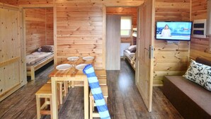 A wooden cabin with a dining area, a TV, and a sofa. - Awesome home in Przewloka with swimming pool (Przewloka)
