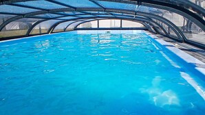 An indoor swimming pool with clear blue water, surrounded by a covered area with a metal roof structure. - Awesome home in Przewloka with swimming pool (Przewloka)