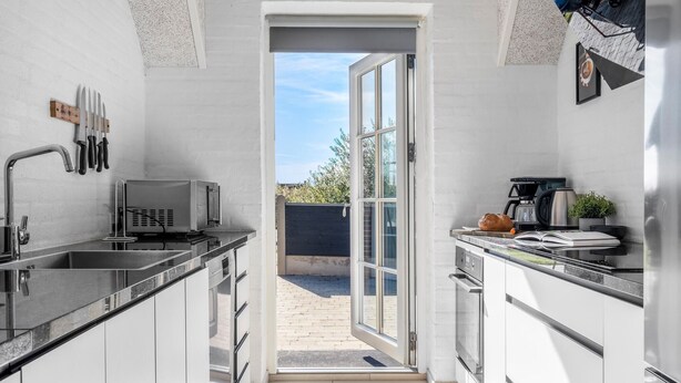 A modern kitchen with a built-in microwave, a coffee maker, and a bread loaf on the counter. - Pet friendly home in Ulfborg with sauna (Ulfborg)