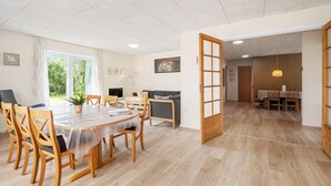 A spacious living area with a dining table, chairs, a sofa, and a view of the outdoors. - Nice home in Skjern with WiFi (Skjern)