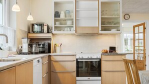 A modern kitchen with wooden cabinets, a built-in oven, a microwave, and a coffee maker. - Nice home in Skjern with WiFi (Skjern)