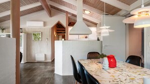 Een moderne keuken met een hoge plafond, zichtbare balken en hanglampen.