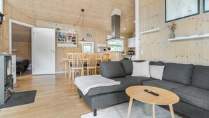 A modern living room with a grey sofa, wooden coffee table, and a fireplace. - Nice home in Grevinge with WiFi (Grevinge)