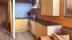 Une cuisine compacte avec des meubles en bois, une cuisinière en acier inoxydable et une machine à café.