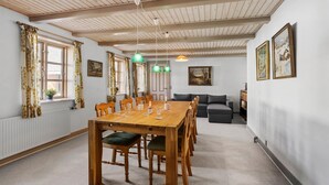Un comedor con mesa y sillas de madera, un sofá y un radiador.