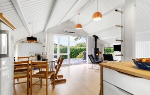 A spacious kitchen with a large window, a built-in stove, and wooden furniture.
